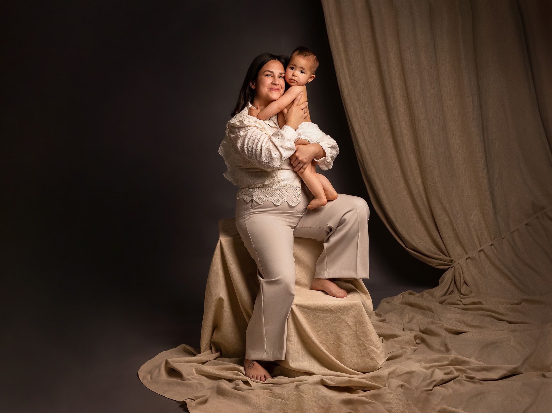 Retrato de mamá abrazando a su bebé con ternura, en una sesión especial para el Día de la Madre.