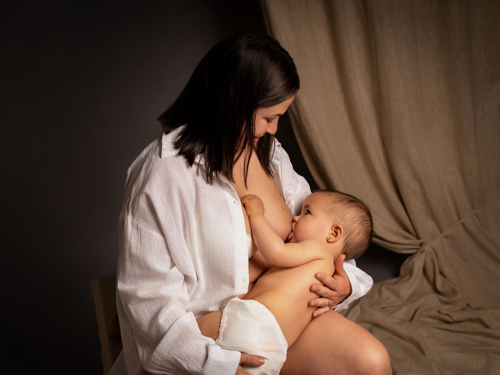 Momento de lactancia entre mamá y su bebé, reflejando el vínculo más puro en el Día de la Madre.