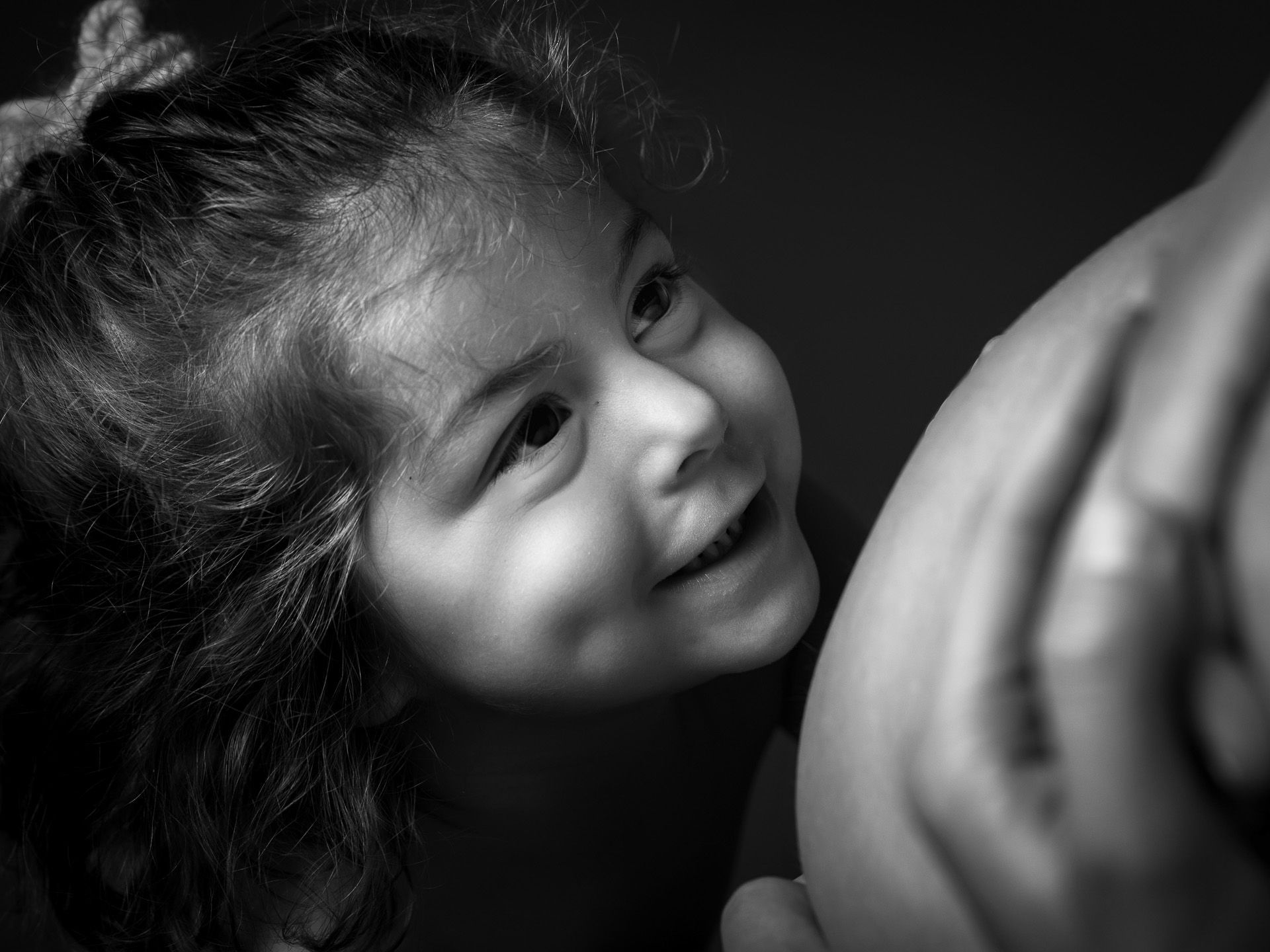 Niña pequeña acariciando con ternura la barriga de su madre embarazada