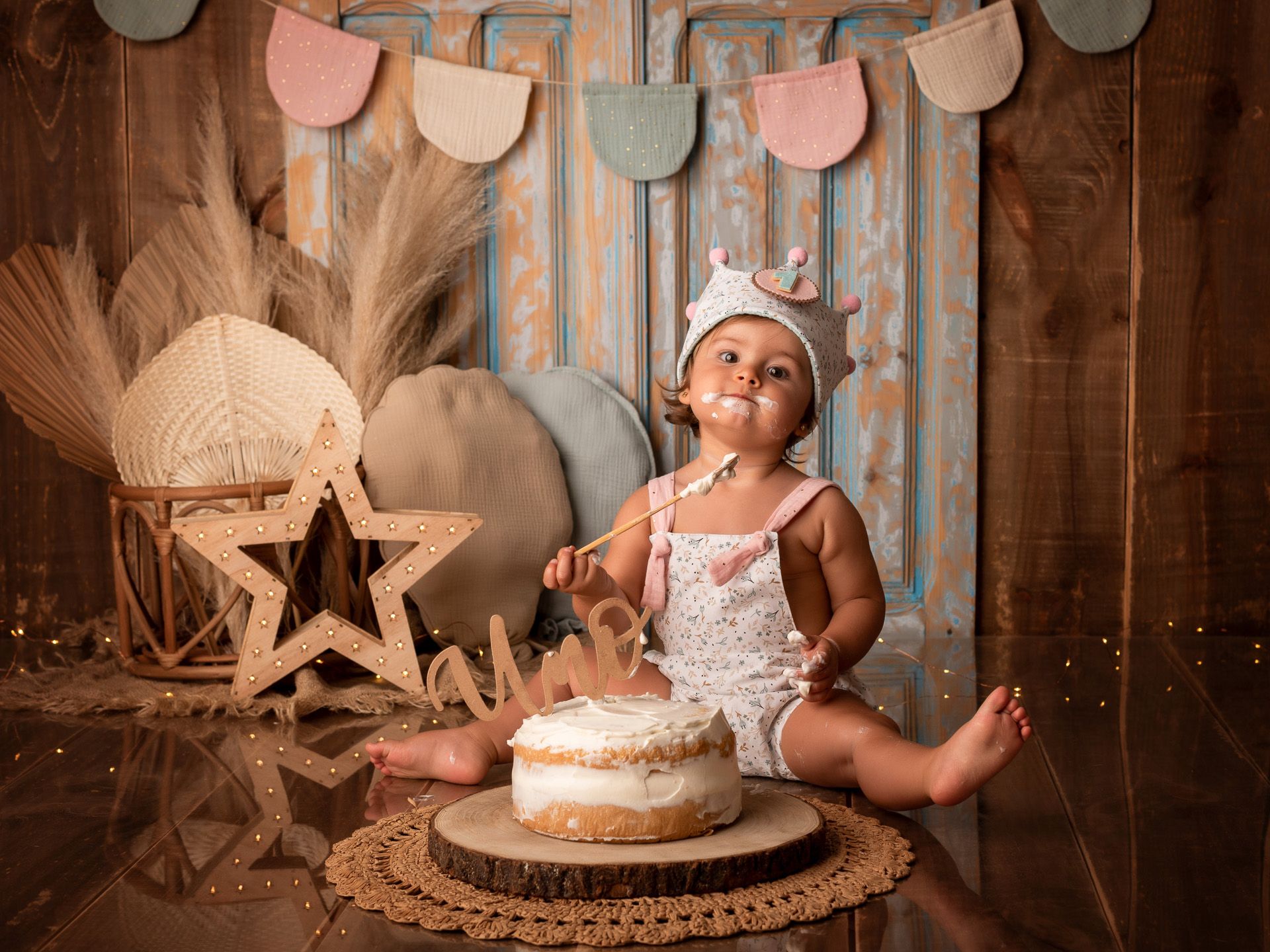 Bebé con pastel en la cara disfrutando con dulzura su primer cumpleaños.