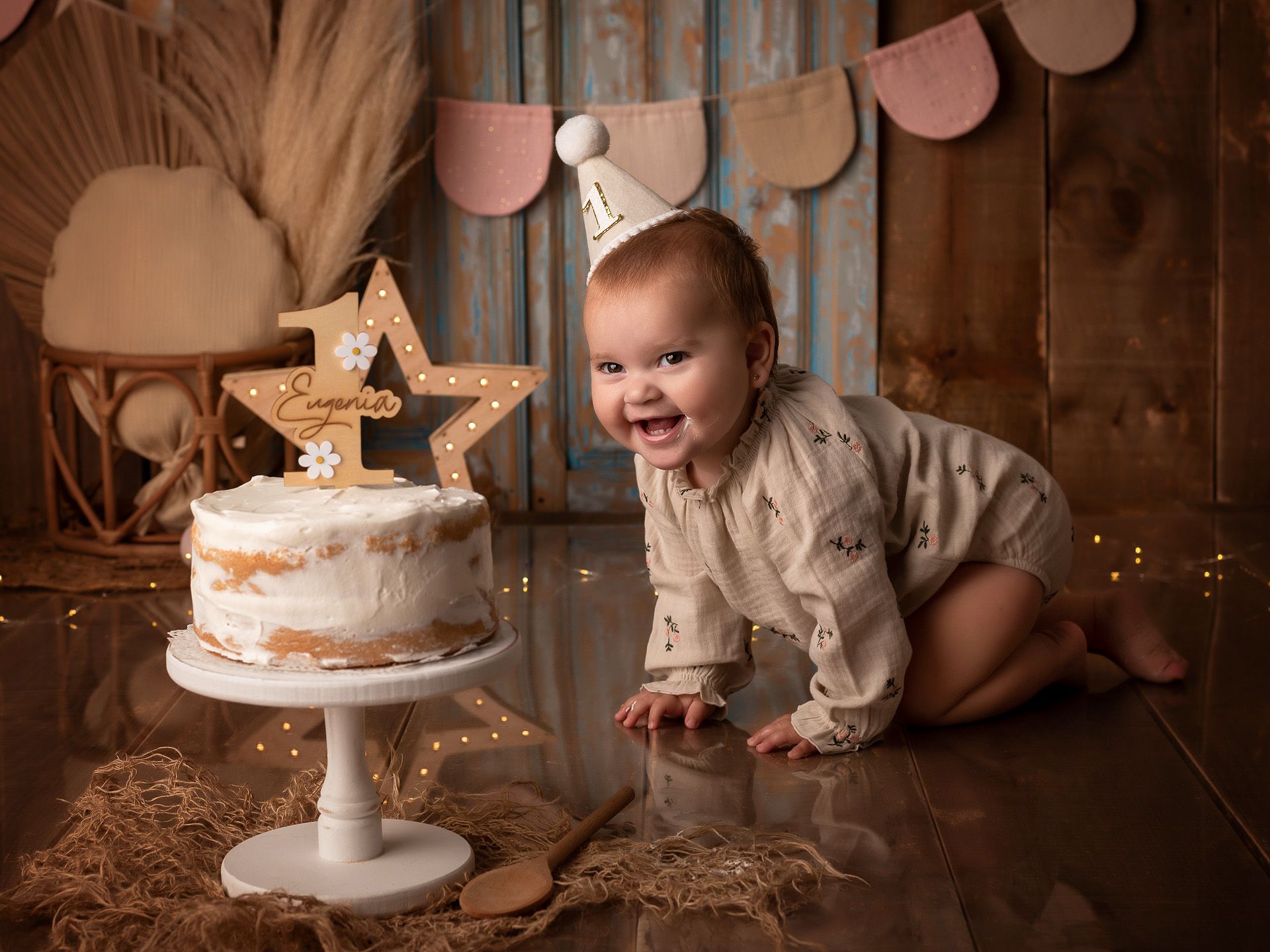 Eugenia gateando feliz hacia su pastel de cumpleaños en sesión Smash Cake.