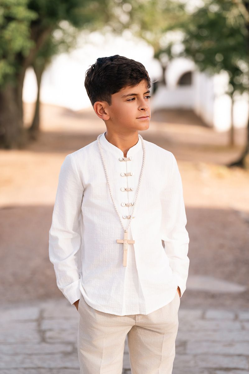 Niño de Comunión con cruz en exterior